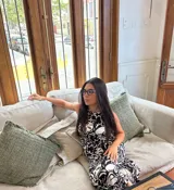 Vestido largo sin mangas, color marrón con estampado abstracto en blanco, escote redondo y tajo lateral.