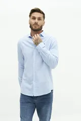 Camisa de lino color beige, de manga larga, corte semi slim y logo bordado en el pecho.