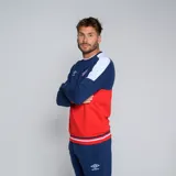 Buzo de cuello redondo Umbro del Club Nacional de Football, modelo Plaqueta CNdeF Oficial para hombre. Diseño con bloques de color azul marino, rojo y blanco. Incluye logo de Umbro y escudo del club en el pecho.