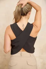 Chaleco color crema de corte sastrero con escote en V y cierre frontal con tres botones. Presenta cruce en la espalda y bolsillos simulados en la parte inferior delantera.