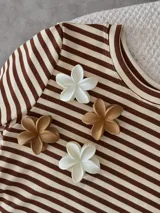 Broche para el pelo con forma de flor, disponible en color blanco y beige.