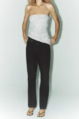 Pantalón de jean celeste, de tiro alto, corte mom fit, con cinco bolsillos y cierre frontal con cremallera y botón metálico.