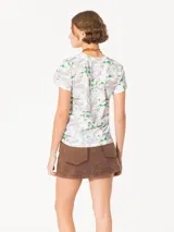 Remera blanca estampada con dibujos de hongos y personajes de fantasía, de corte recto y mangas cortas.