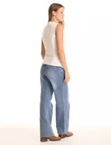 Chaleco sastrero color crema, con cuello redondo, cierre frontal con botones forrados y bolsillos simulados. El ruedo frontal tiene un acabado en pico.