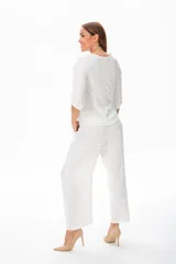Pantalón palazzo blanco con estampado de hojas doradas, con bolsillos laterales y corte holgado.