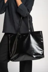 Bolso tipo tote negro de cuero vegano, con doble asa de hombro.