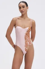 Body rosa blush con breteles finos y copas suaves tipo corset. Presenta una aplicación lateral de hojas en lentejuelas color cobre.