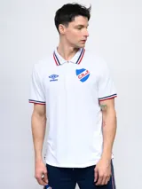 Remera polo azul con cierre, puños y cuello con detalle tricolor. Incluye logo de Umbro y escudo del Club Nacional de Football.