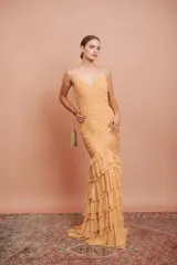 Vestido largo color durazno, entallado, con escote en V, breteles finos, drapeado en el frente y falda con volados.