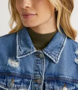 Campera de jean celeste con cuello camisero, cierre frontal con botones, bolsillos delanteros y recortes.
