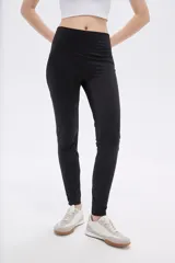 Calza negra de poliamida, corte skinny y tiro alto.