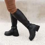 Bota de caña alta color marrón, confeccionada en cuero vacuno. Tiene suela de goma sport artesanal, cierre YKK del lado interno y horma de punta redonda.