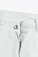 Jeans tobilleros de tiro alto color blanco, corte recto y bajo sin costura. Cierre frontal cruzado con cremallera y botones.