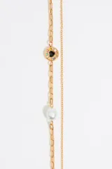 Collar dorado de doble cadena con dije de corazón negro con borde dorado.