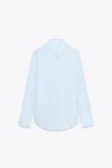 Camisa blanca de lyocell con cuello solapa, manga larga y bajo asimétrico. Cierre frontal con botones.