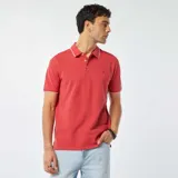 Chomba de piqué color rojo con cuello clásico y borde blanco, de corte recto y manga corta.