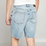 Bermudas de jean celeste con efecto desgastado y roturas.