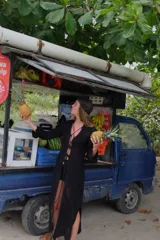 Saco largo de tejido de punto negro con diseño calado y acordonado en el frente, de manga larga.