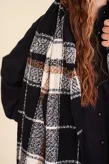 Bufanda amplia de algodón y poliéster, con diseño escocés en tonos negro, blanco y mostaza.