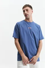 Remera de manga corta color gris claro con cuello redondo y logo de la marca estampado en el pecho.