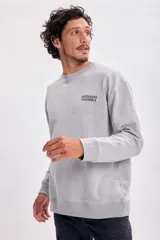 Buzo deportivo gris con cuello redondo y mangas largas. Estampado frontal con el texto "Avengers Assemble" en azul.