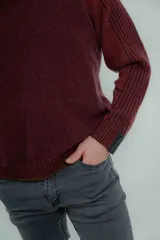 Sweater marrón de lana lambswool con cuello redondo y mangas largas. Presenta un diseño de punto texturizado en el cuerpo y mangas con detalle de punto acanalado en hombros y puños.