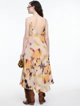 Vestido largo de breteles finos confeccionado en viscosa crinkled con estampa de manchas. De escote en V y silueta evasé, tiene una caída fluida que acompaña el movimiento. El efecto arrugado del tejido le da textura y carácter a una prenda fresca y versátil.