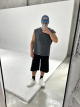 Remera sin mangas gris con efecto acid wash, corte holgado y largo semi boxy.