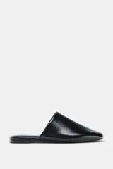 Zapato plano destalonado de piel color negro, con punta redonda y suela de 1,5 cm.