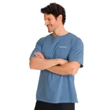 Remera celeste de algodón con cuello redondo y mangas cortas. Presenta el logo de Caterpillar bordado en el pecho y un parche con el logo de la marca en la manga.