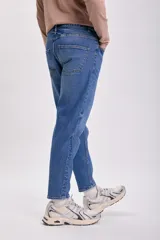 Pantalón jean de corte slim taper color azul medio.