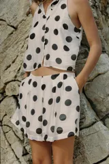 Bermuda blanca con estampado de lunares negros, de tiro medio con pinzas y bolsillos frontales.