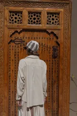 Camisa blanca de lino con bordados dorados de árboles, corte recto, cuello camisero y mangas largas con puños abotonados.