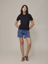 Remera negra de cuello redondo y manga corta con logo pequeño bordado en el pecho.