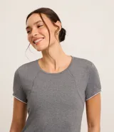 Remera deportiva gris de microfibra ligera, con cuello redondo, mangas cortas y frisos contrastantes blancos en la espalda.
