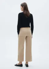 Pantalón culotte color beige de pana con tiro alto, corte ancho, largo cropped y bolsillos delanteros de parche. Incluye cinturón negro con hebilla plateada.
