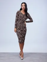 Vestido midi de seda fría estampada con diseño animal print en tonos marrón, beige y negro. Tiene escote en V, mangas largas y lazo ajustable en la cintura.