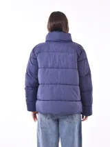 Campera puffer color gris topo, con cuello alto y cierre frontal.