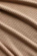 Buzo de punto acanalado color beige, de corte entallado, con escote bote, mangas largas y aberturas laterales y en los puños.