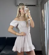Vestido corto blanco con escote off-shoulder, mangas cortas abullonadas y cintura elastizada.