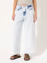 Pantalón de jean celeste con lavado bleach, corte wide leg y largo cropped.