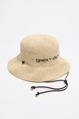 Gorro tipo bucket de rafia color beige con logo de la marca Bimba y Lola bordado en negro. Tiene cordón ajustable negro con detalles dorados.