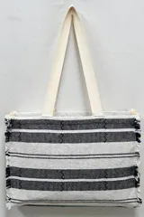 Bolso tipo tote rayado en blanco y negro con flecos en los bordes.