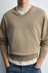Jersey de hombre color beige, de corte relaxed fit, tejido en hilatura con algodón y ramio. Tiene cuello pico, manga larga y acabados en rib.