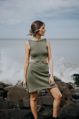 Vestido corto de tejido de punto color verde oliva con lurex dorado, sin mangas y con aberturas laterales en la cintura.