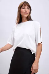 Remera blanca de algodón con cuello redondo y mangas cortas con aberturas laterales.