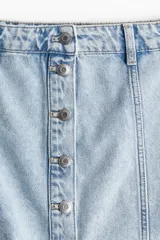 Minifalda evasé de denim celeste con botonadura frontal y costuras a la vista.
