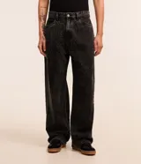 Pantalón masculino de jeans azul oscuro con efecto lavado, corte super baggy, cintura con trabillas, cierre tradicional, bolsillos y detalles de desgaste.
