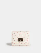 Billetera de cuerina color crema con estampado de pequeñas rosas rosadas, con broche metálico plateado y compartimentos para tarjetas.