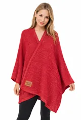 Ruana tejida de punto color rojo con hilos de lurex que le dan un brillo sutil. Presenta un diseño asimétrico y un cuello en V. Incluye una etiqueta de cuero sintético con la inscripción "PURA LANA".